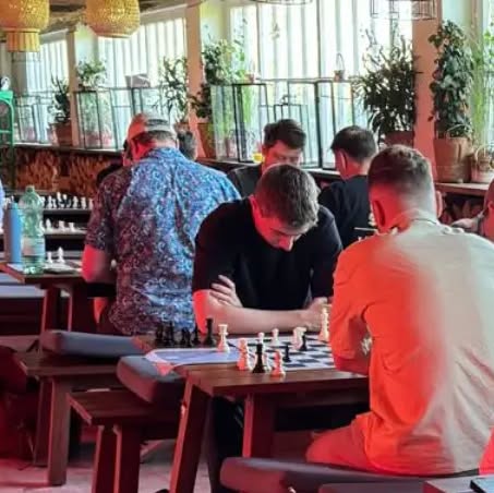 Zwei Spieler sitzen sich bei einem Turnier am Schachbrett gegenüber.